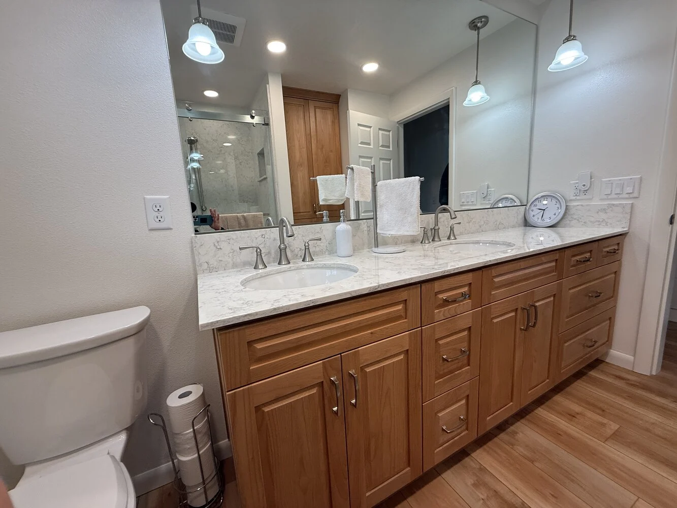 Custom bathroom double vanity remodel with marble counters and wood cabinetry